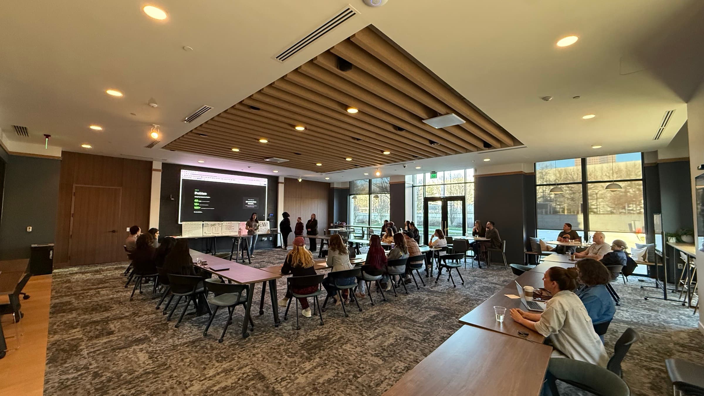 Women entrepreneurs at a Theanna session, one presenting to the room while others work at tables